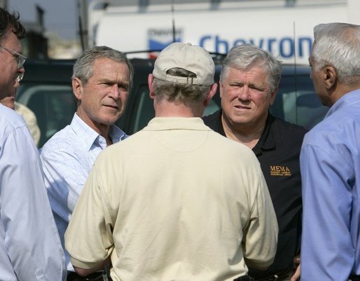 Two men—George W. Bush and Haley Barbour—are seen looking at another man who is facing them