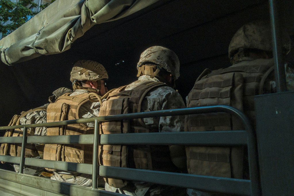 Men in army suits sitting in a green truck