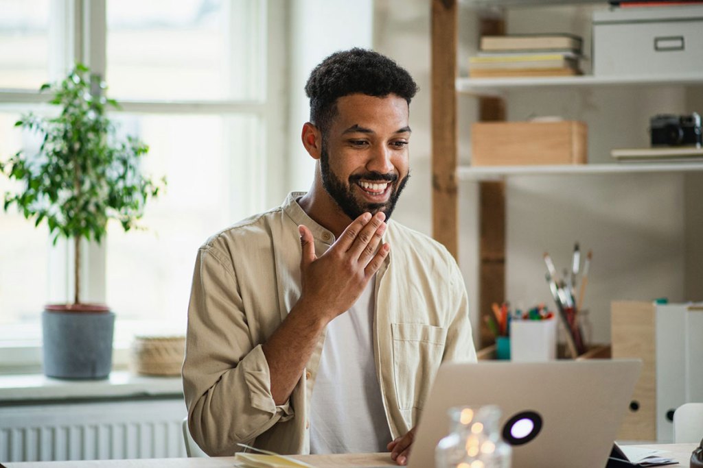 Young man with laptop signing on a video call