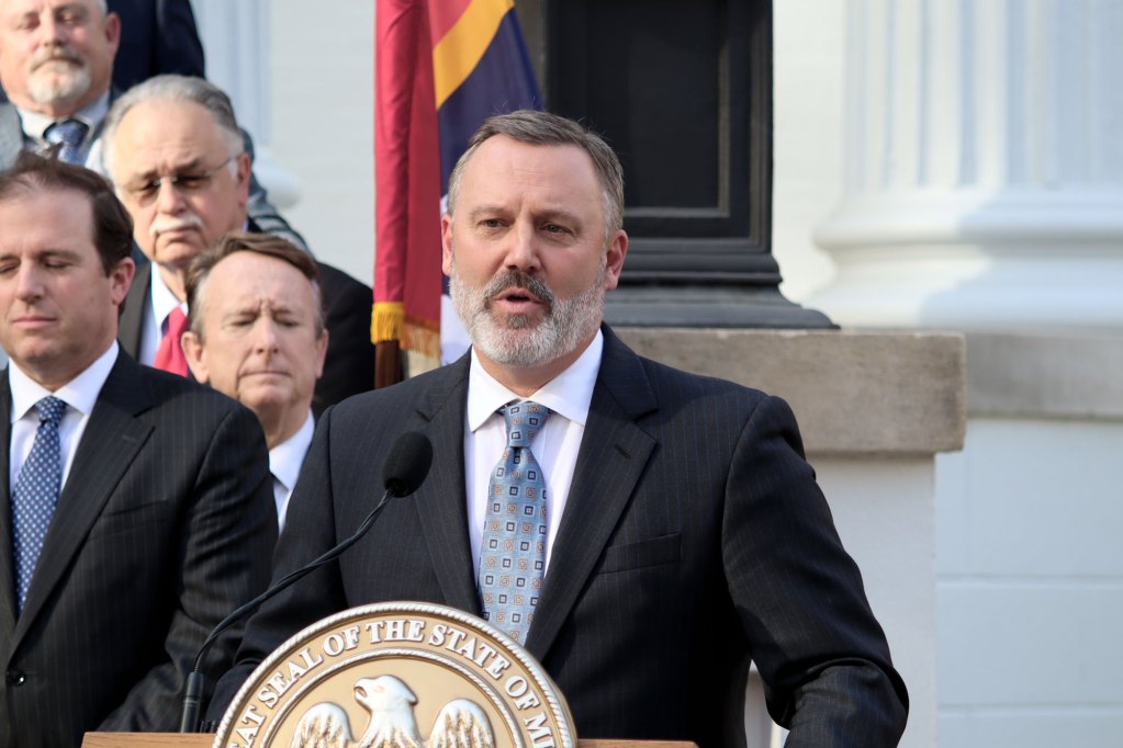 Speaker of the House Jason White speaks at presser outside with the Mississippi State flag behind him