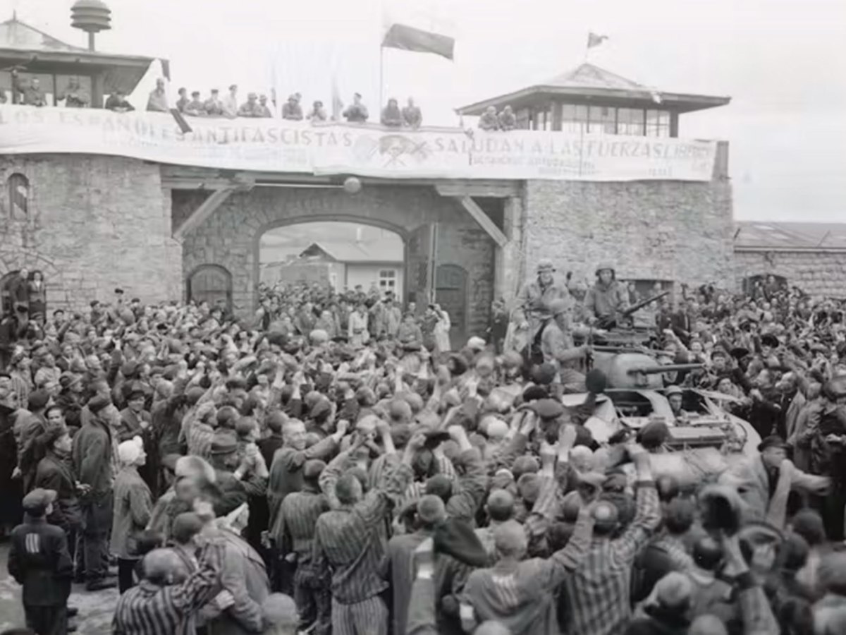 A black and white photo of men celebrating outside of a brick castle like structure