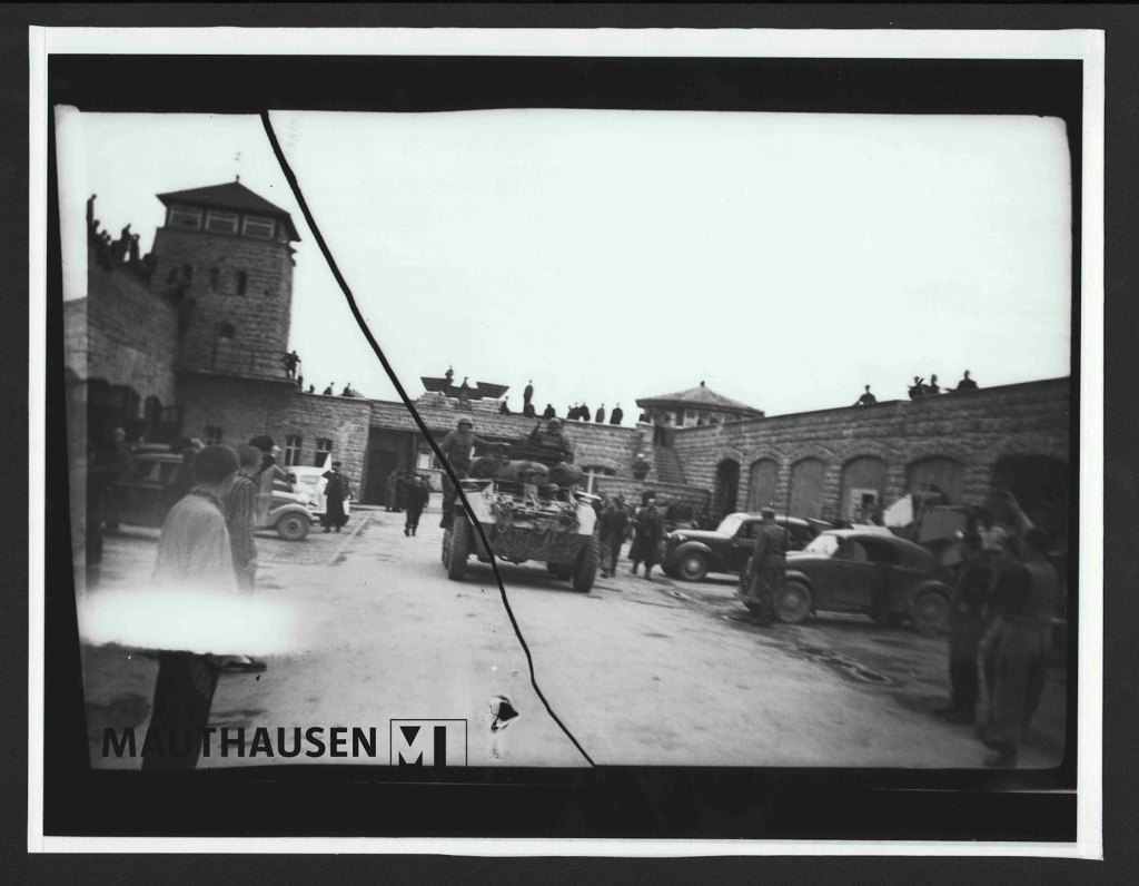 A black and white photo of men entering a fort with brick walls surrounding it