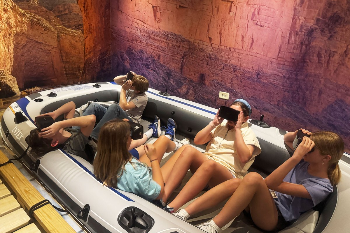 Kids in a inflatable pool looking through black virtual reality googles