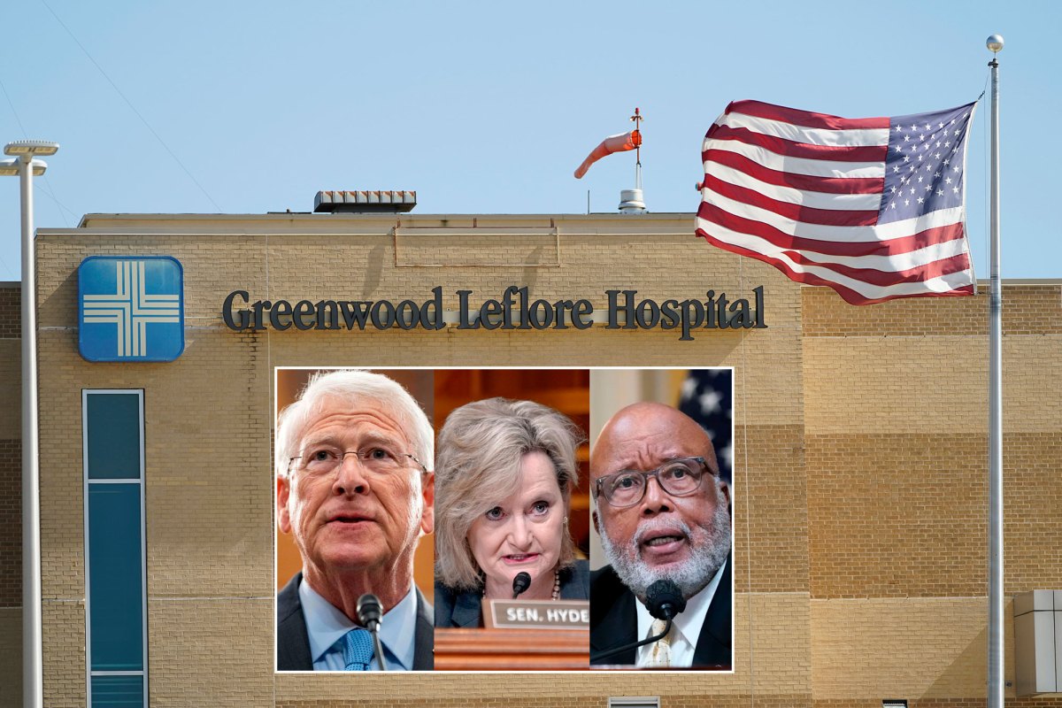 A brown brick building with an American flag in front of it