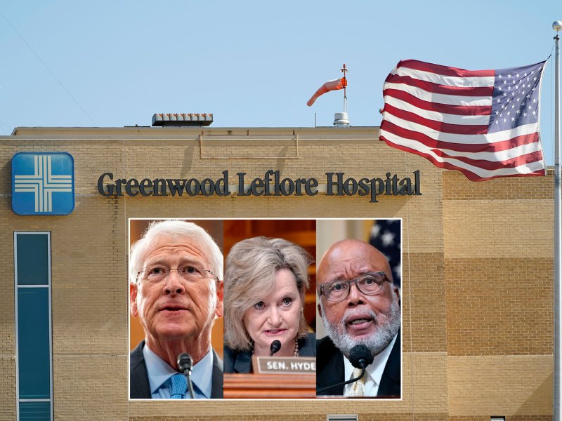 A brown brick building with an American flag in front of it