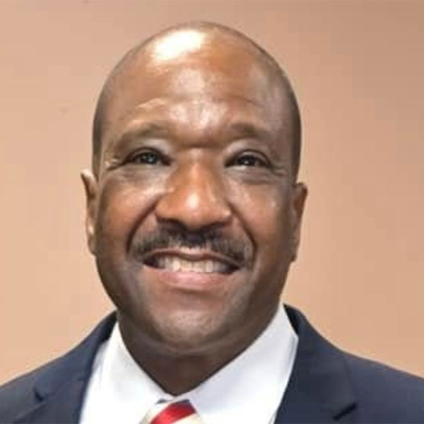 Closeup of a smiling man in a suit on a brown background