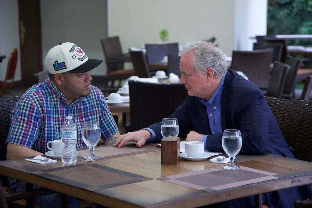 Two men sit at a table in a restaurant