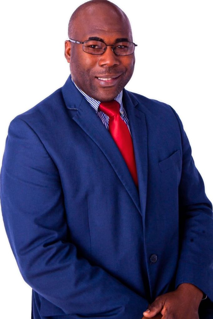 A man wearing glasses, a blue suit, and a red tie