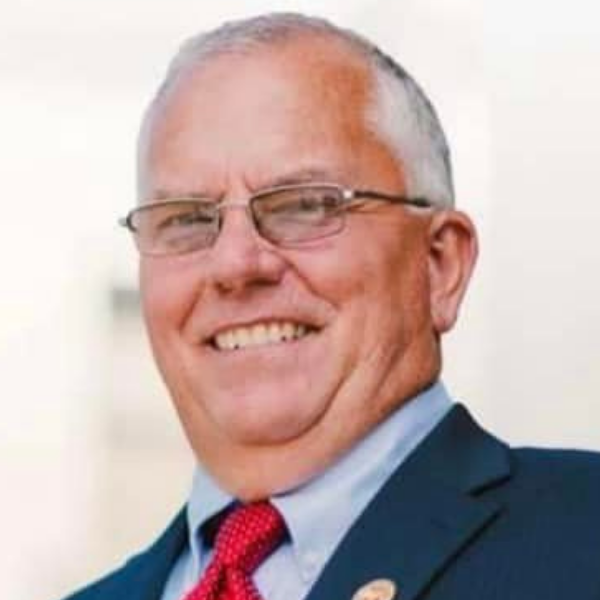 Closeup of an older man in a suit and glasses