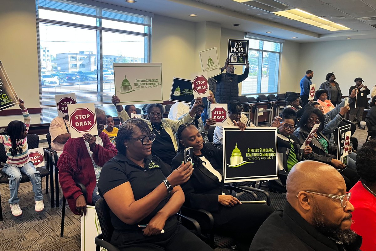 A room full of people holding signs that says, "Stop Drax".