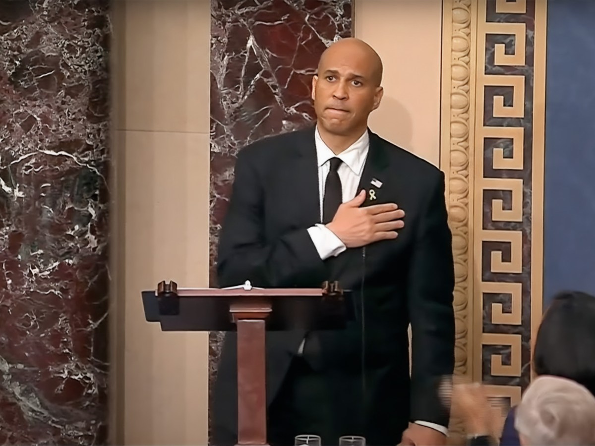 a photo of Cory Booker standing on the us senate floor and holding his chest