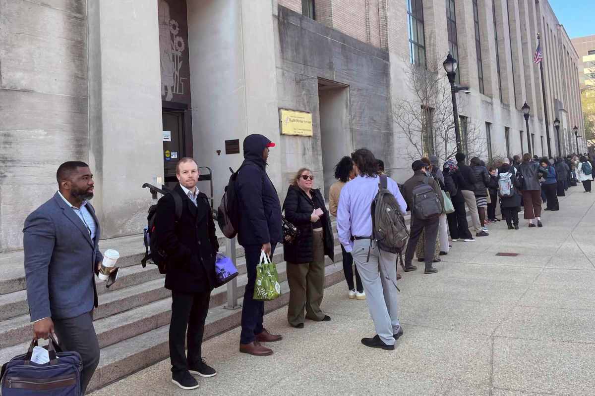 a photo of people wearing suits and hoodies and carrying backs and wearing backpacks standing outside a large building