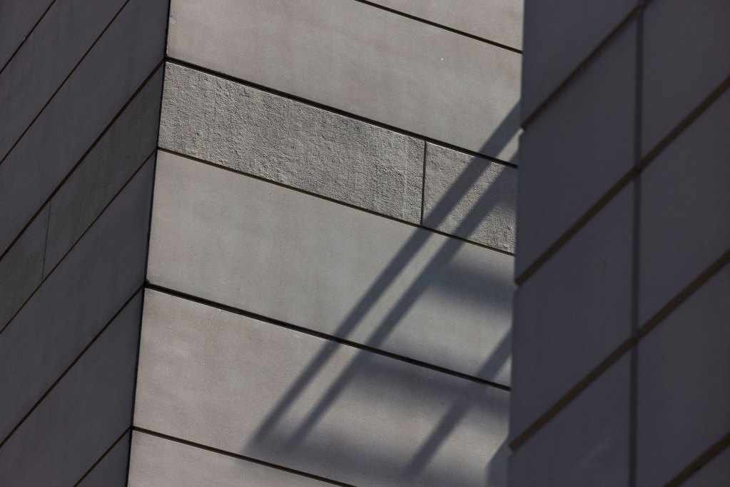A photo shows shadows falling on the outside walls of a jail building.