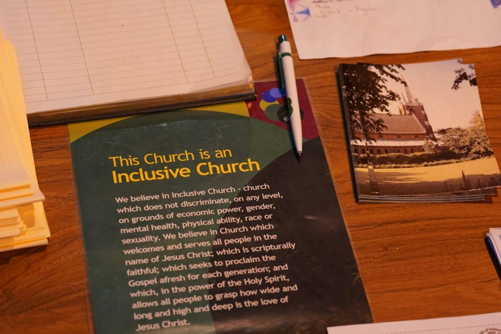 A pamphlet on a table says 'This Church is an Inclusive Church