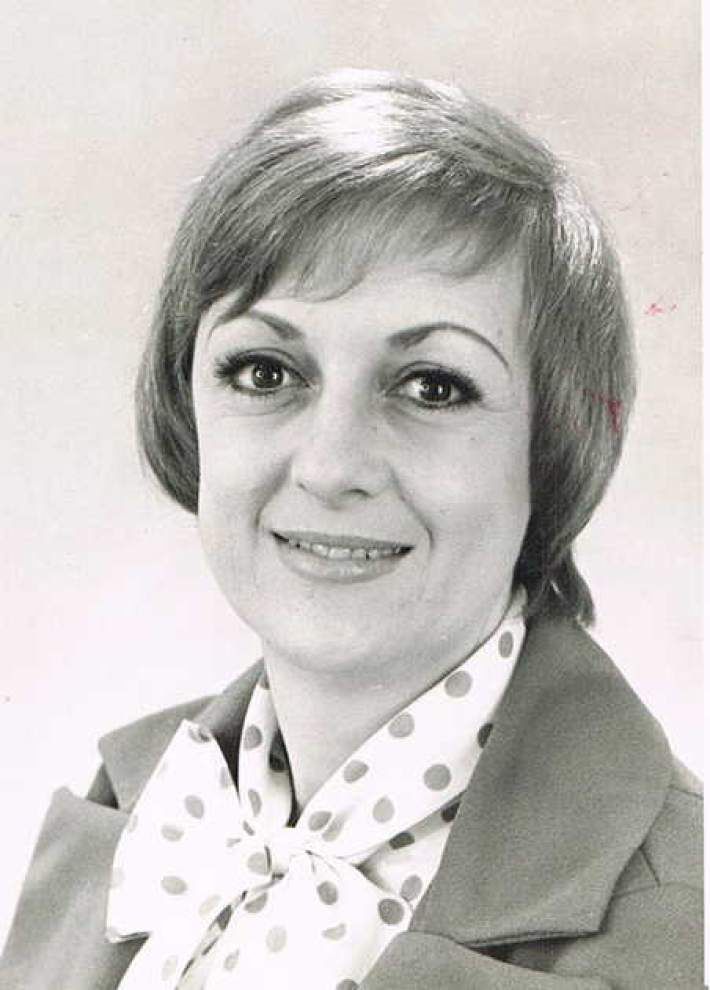 An old 1970's photo of a woman in blouse and jacket