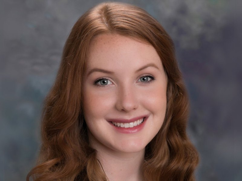 A portrait of a teenager with long auburn hair
