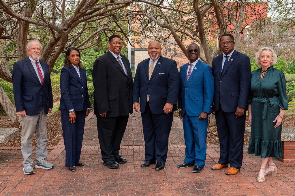 Seven councilpersons stand outside for a photo