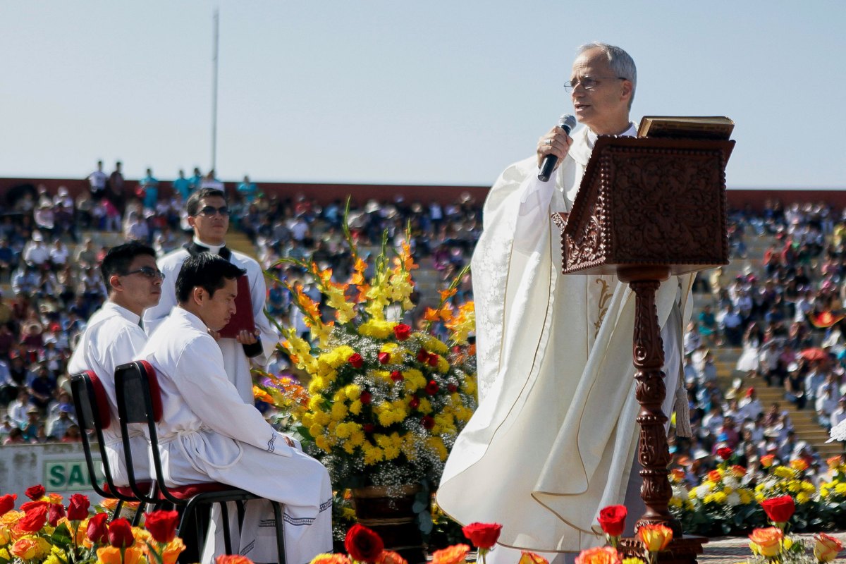 The New Pope speaking to a stadium of people wearing a white robe and holding a mic