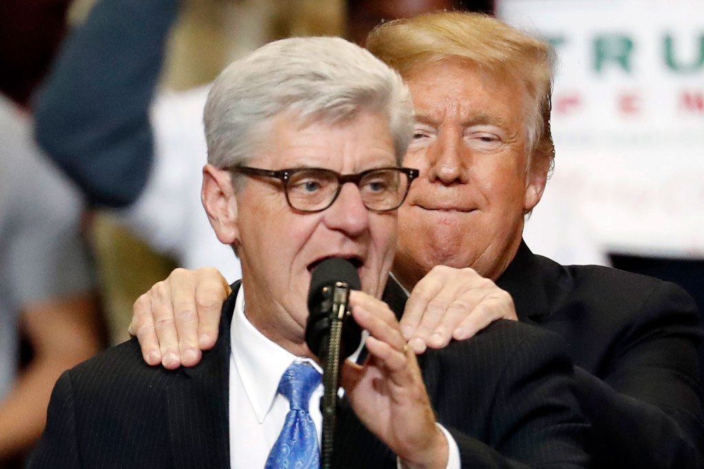 Donald Trump gives a shoulder massage to Phil Bryant as Bryant speaks on stage