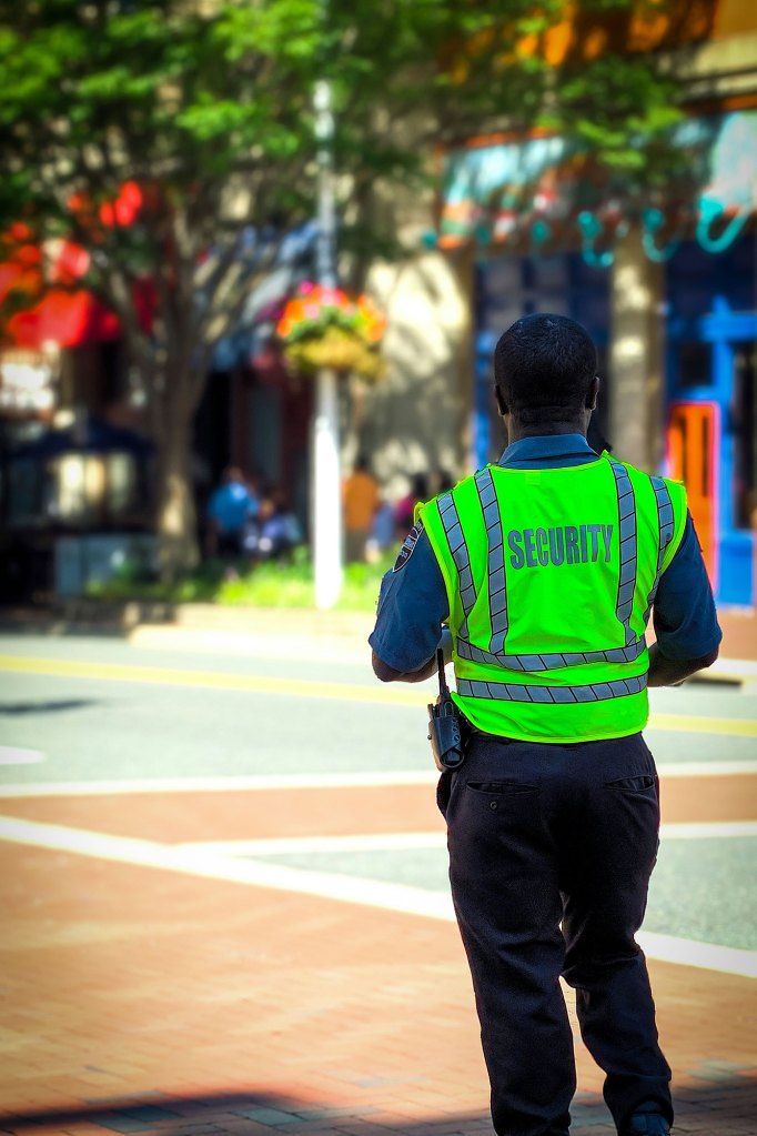 Security guard in neon vest walking outside