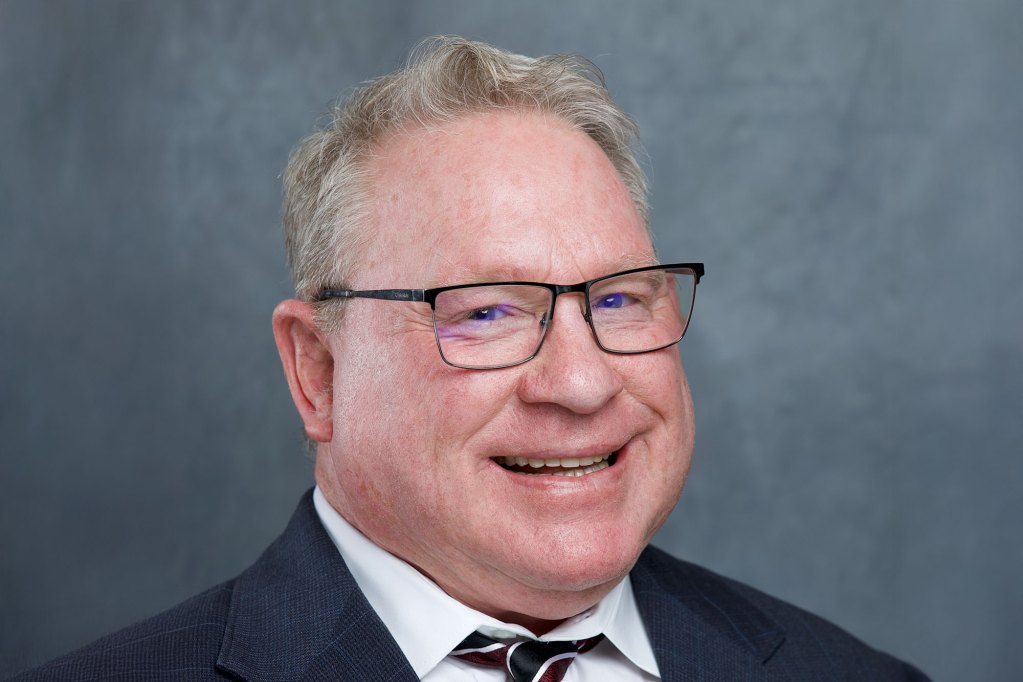 Portrait of a man in a suit wearing glasses