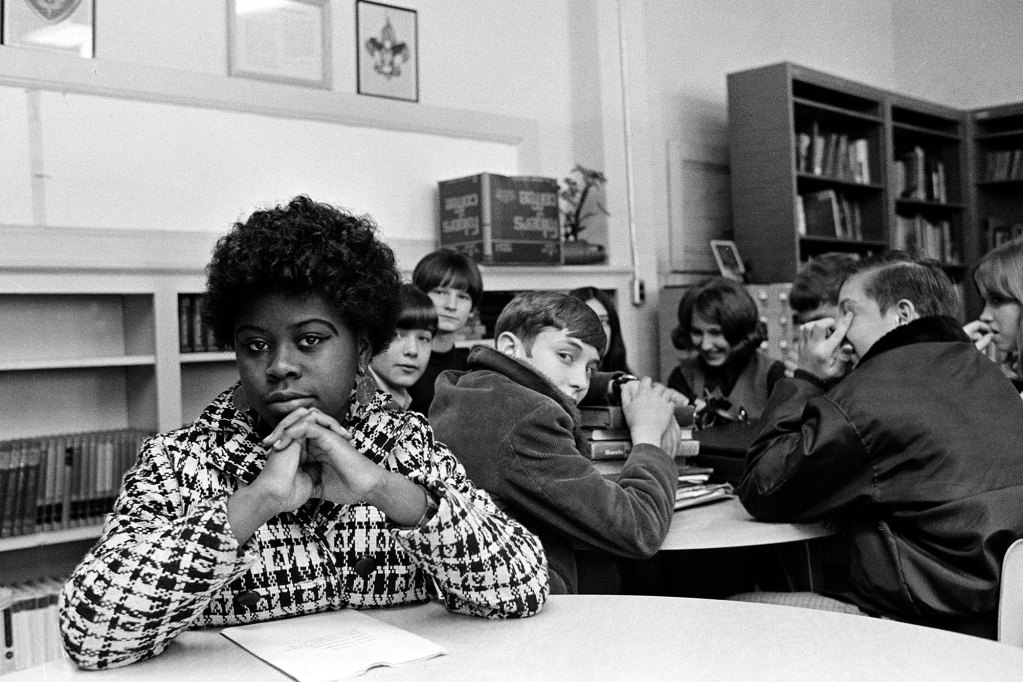 A Black student sits with white students during a study session at a junior high school