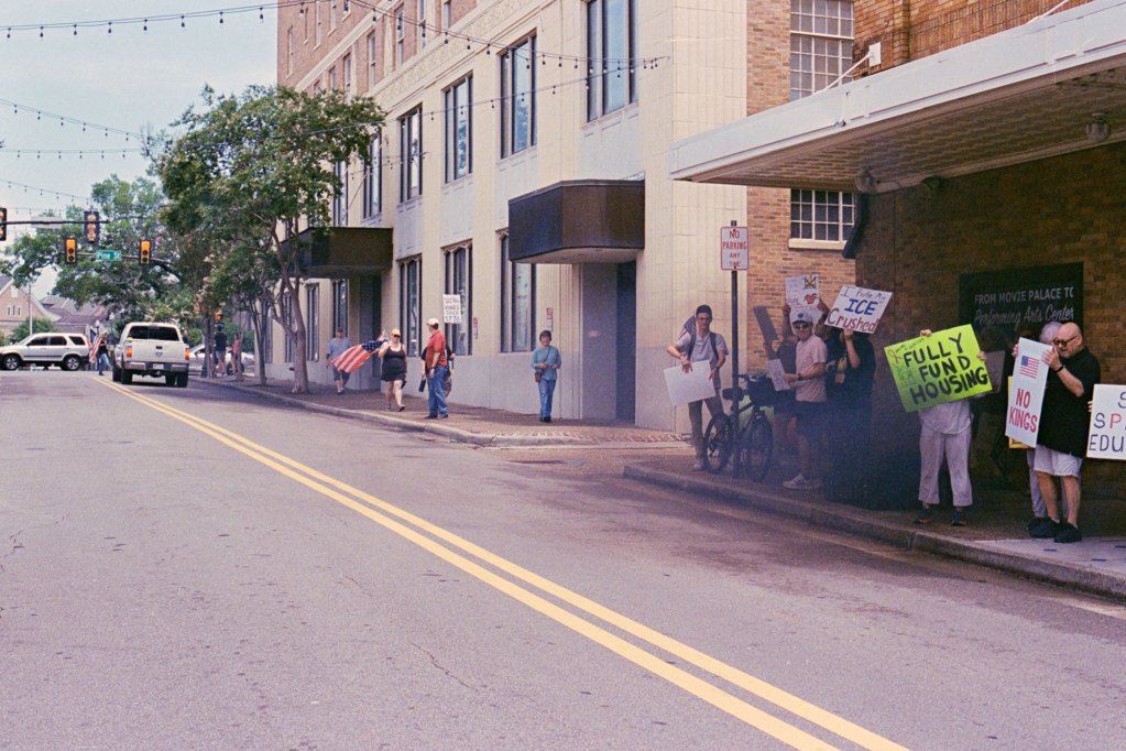 Truck exhaust billows in front of protesters holding signs