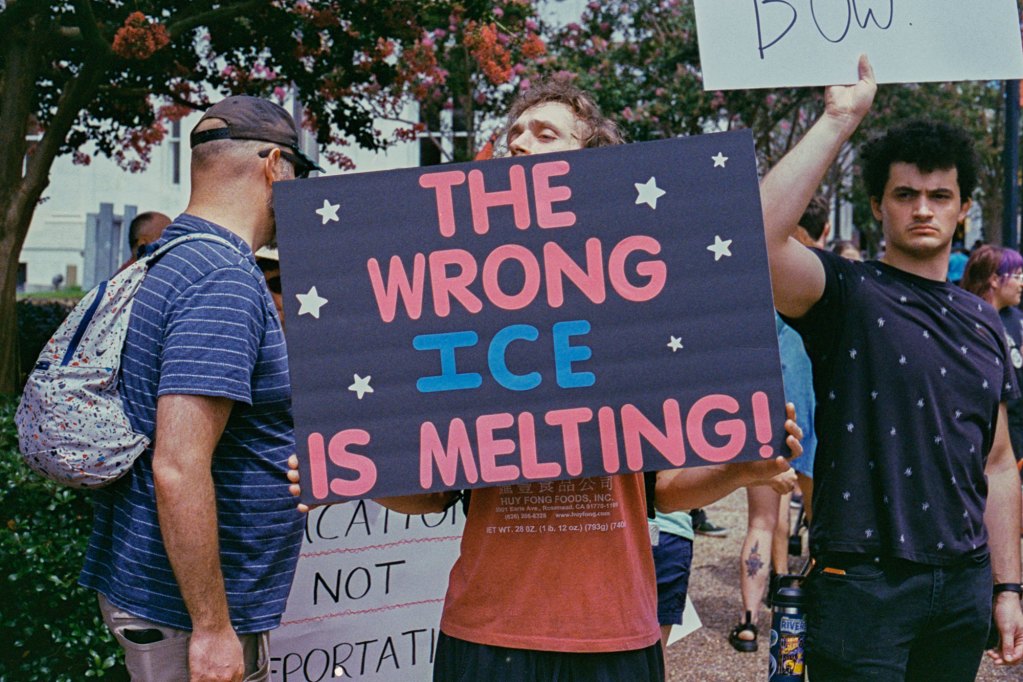 Protesters hold signs, one reads "The wrong ice is melting"