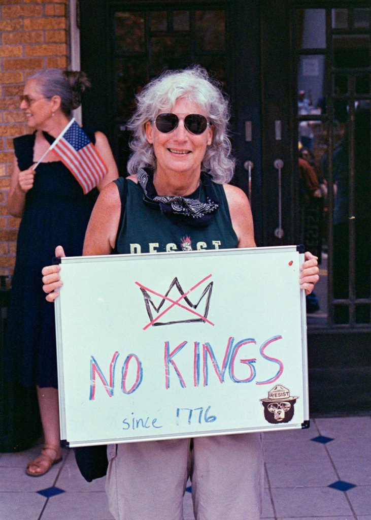 A protester holds a sign that says "No kings since 1776"