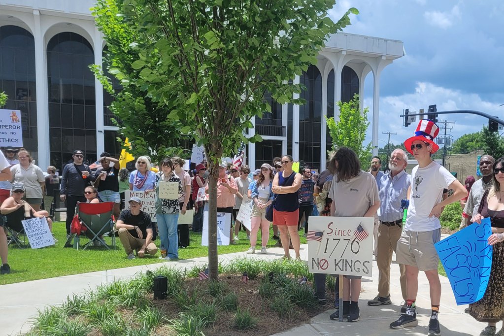 Protesters hold up signs, one reads "Since 1776 No Kings"
