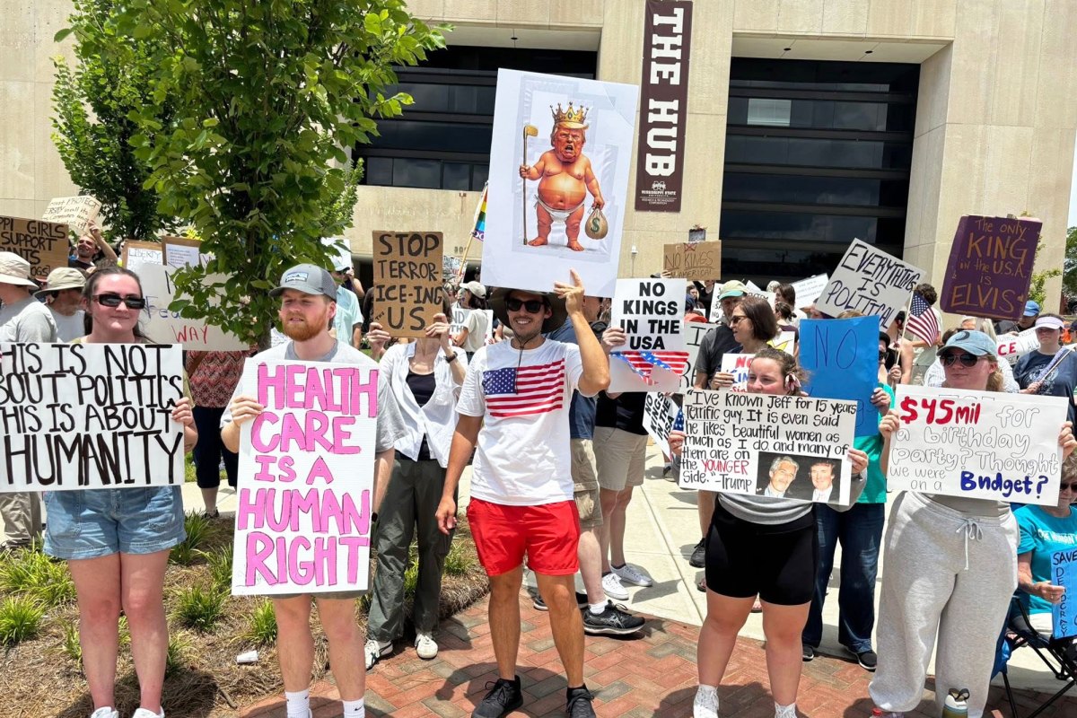 Protesters hold up signs, one reads "Health care is a human right"