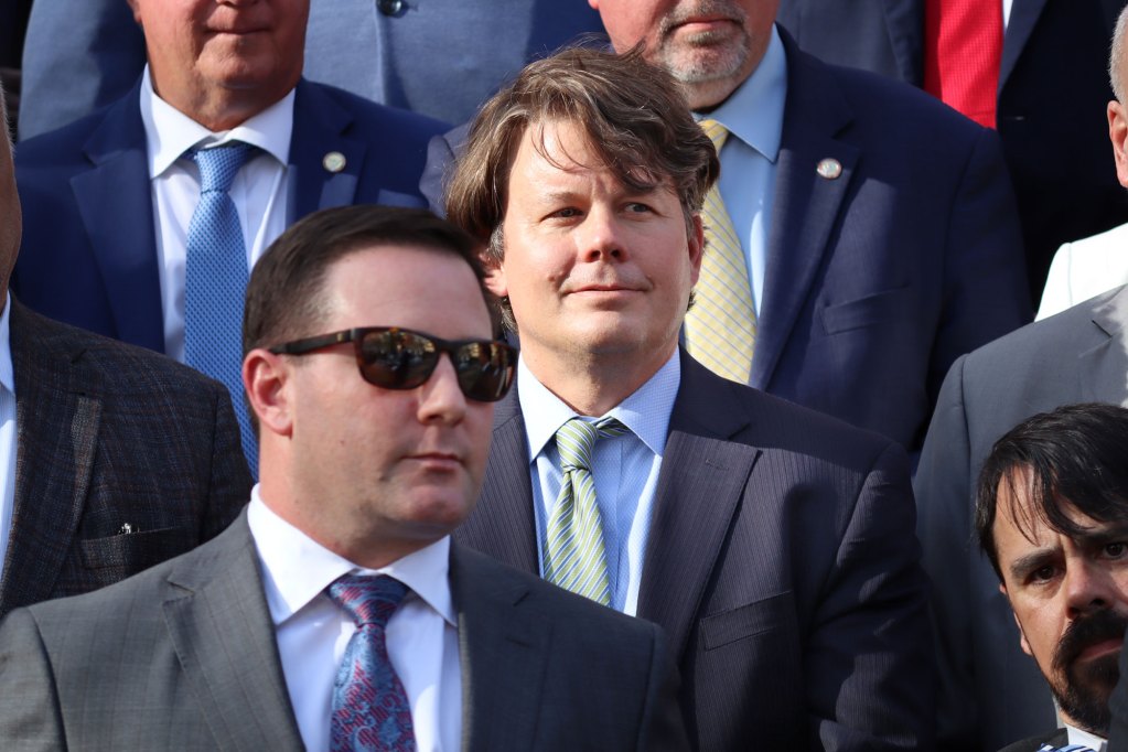 A closeup of men in suits standing outside on stairs