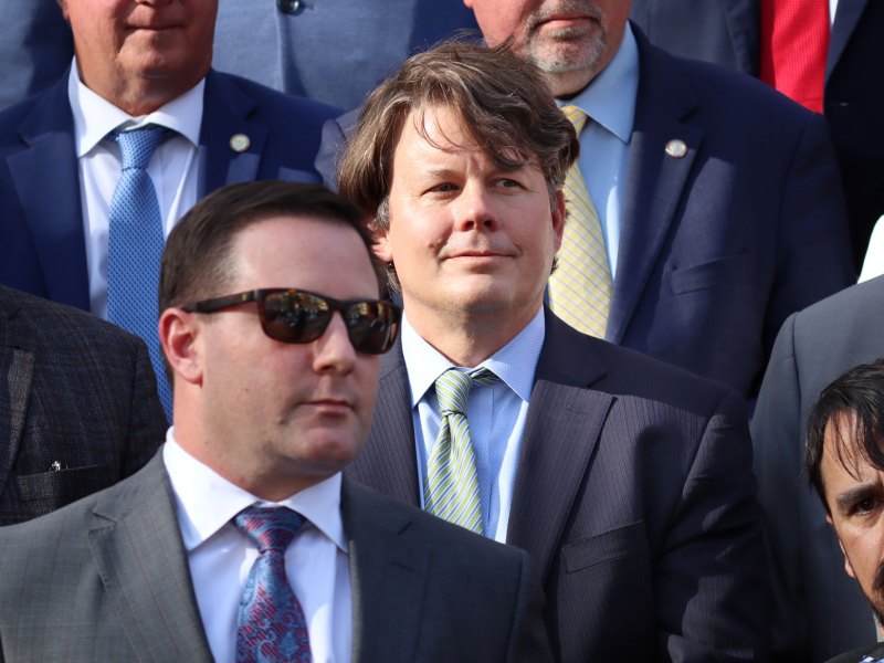 A closeup of men in suits standing outside on stairs