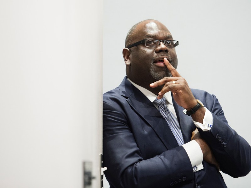 Judge Reeves standing in a doorway with a finger over his mouth and his other fingers resting under his chin