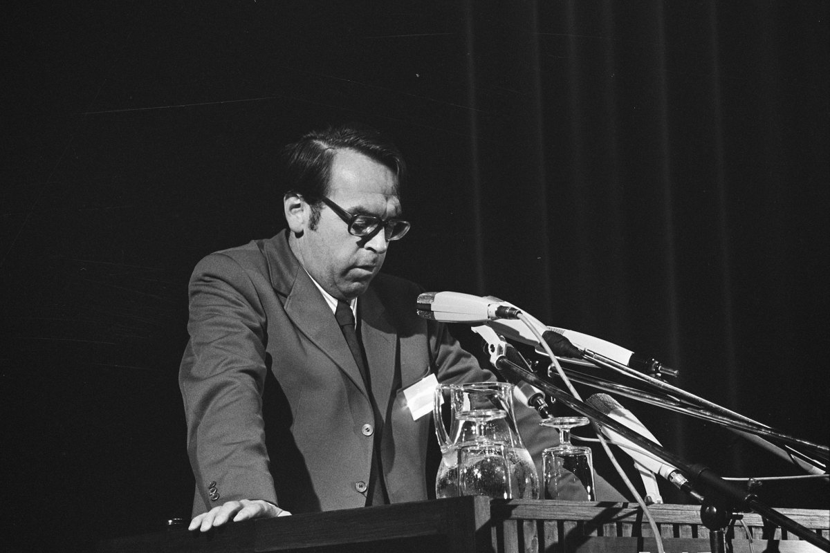 A black and white photo of Moltmann speaking on stage