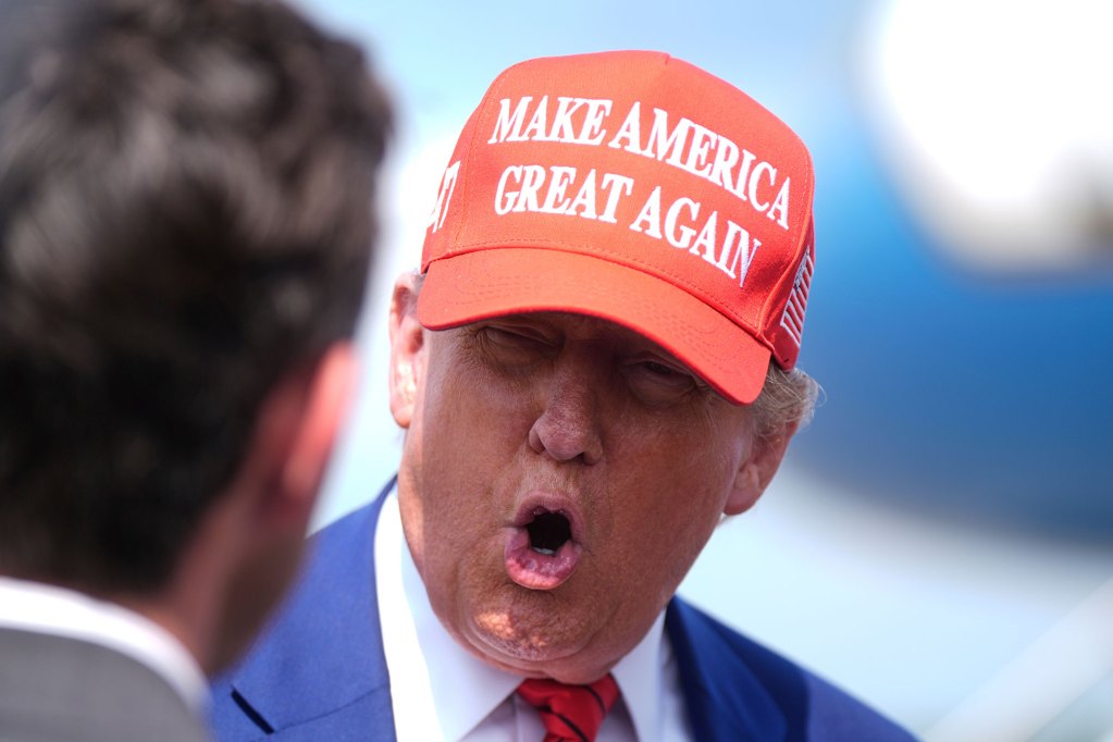 Donald Trump speaking, wearing a red Make America Great Again cap