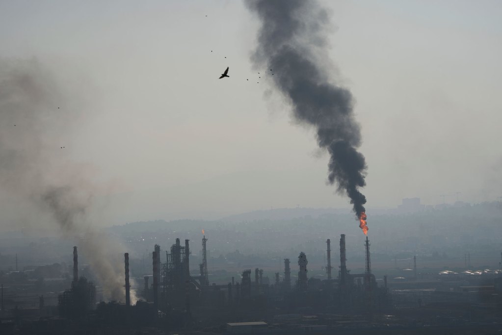 Smoke fills up the sky from an oil refinery