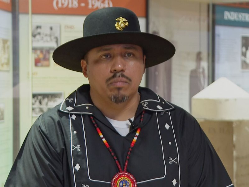 A man wearing choctaw native attire and hat in black