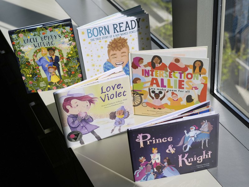 Five colorful children's books sit on a windowsill