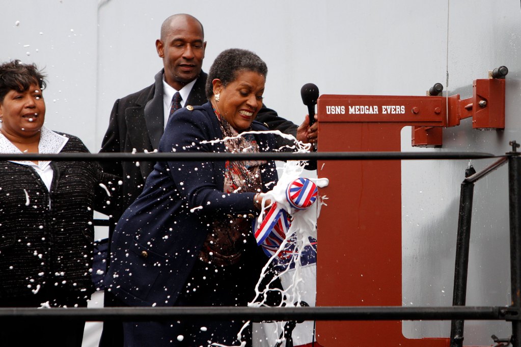 Myrlie Evers-Williams breaks a bottle of champaign on the USNS Medgar Evers