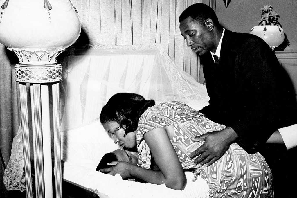 Myrlie Louise Evers leans down to kiss her late husband's forehead in the casket