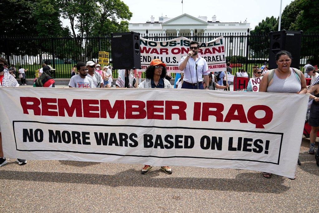 Protesters outside of the White House holding a large banner that reads "Remember Iraq - No more wars based on lies!"
