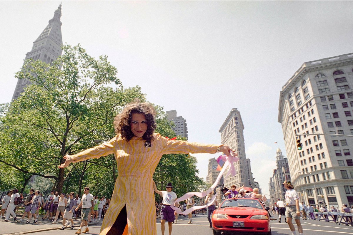 Sylvia Rivera standing in a pride march in New York, smiling