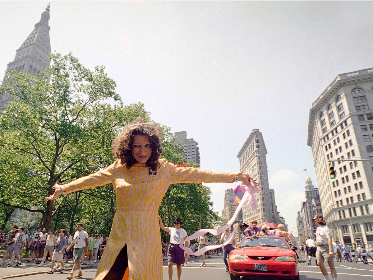 Sylvia Rivera standing in a pride march in New York, smiling