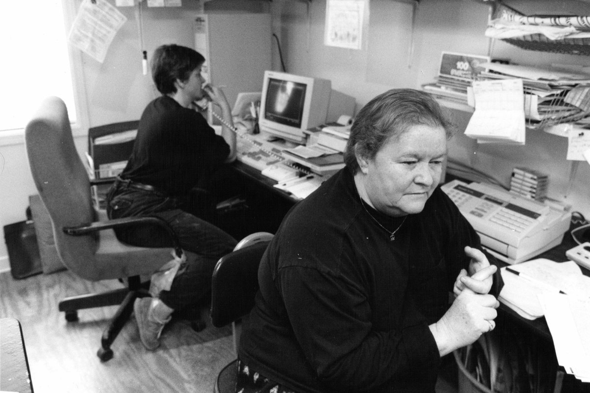 A black and white photo of two women working in an office