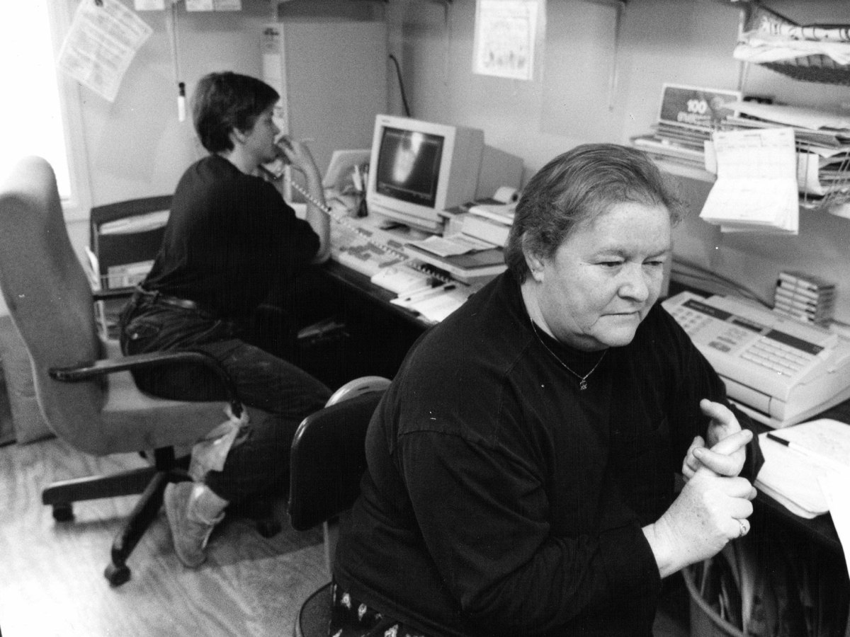 A black and white photo of two women working in an office