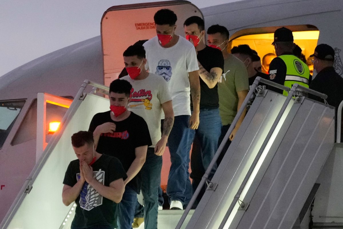 Men in red health masks unboard a plane