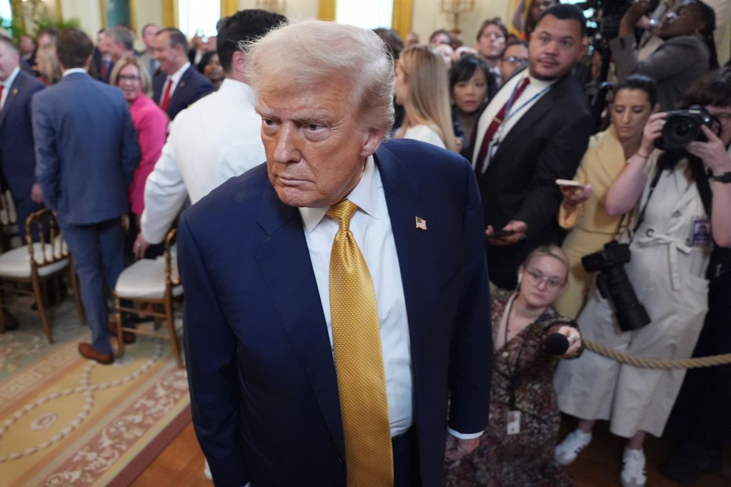 Donald Trump leaves a busy room as reporters try to interview him