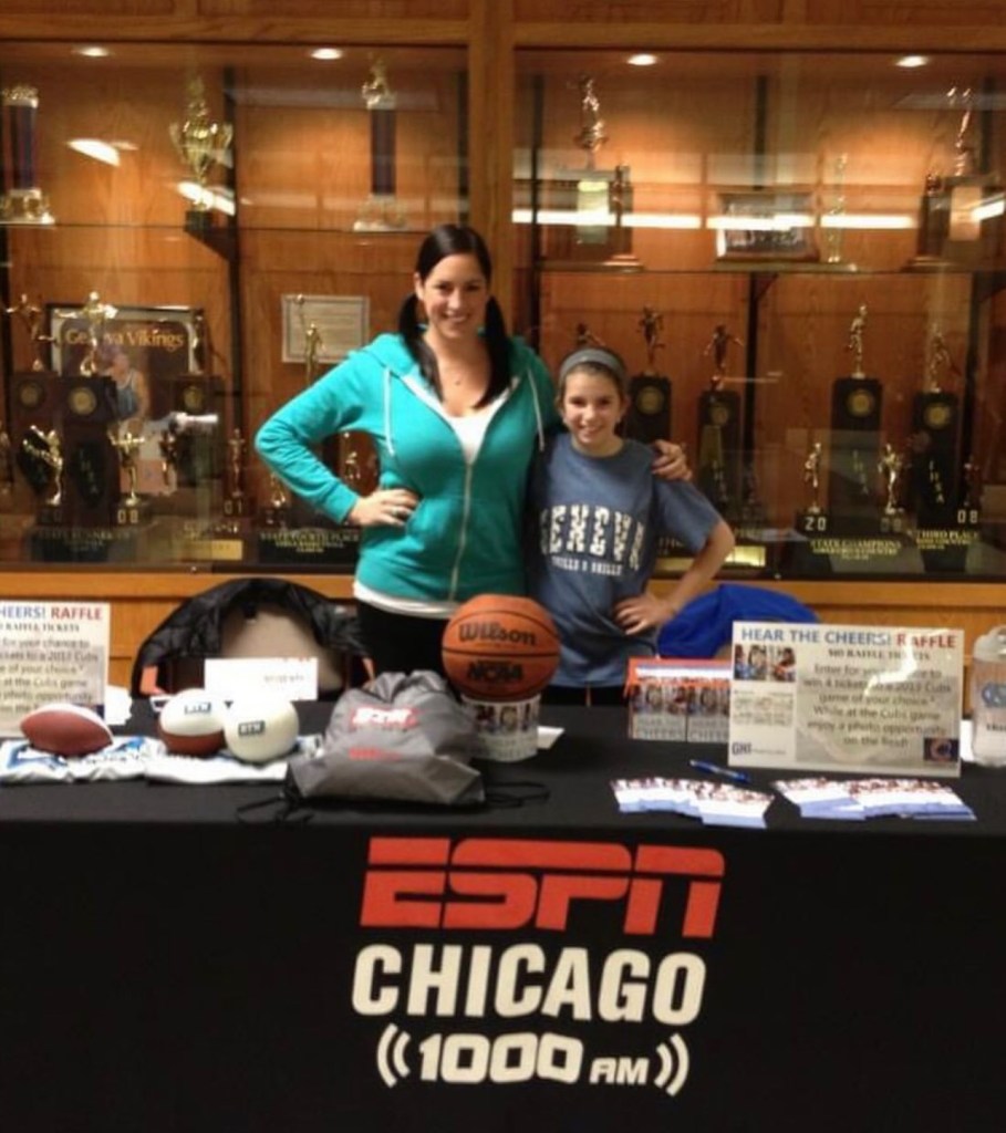 Woman and child standing behind table in front of trophy case, the table is labeled ESPN Chicago