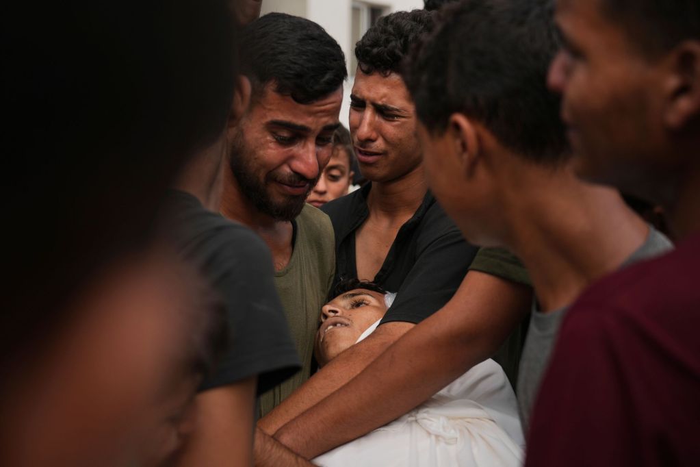 People mourn over the body of a family member